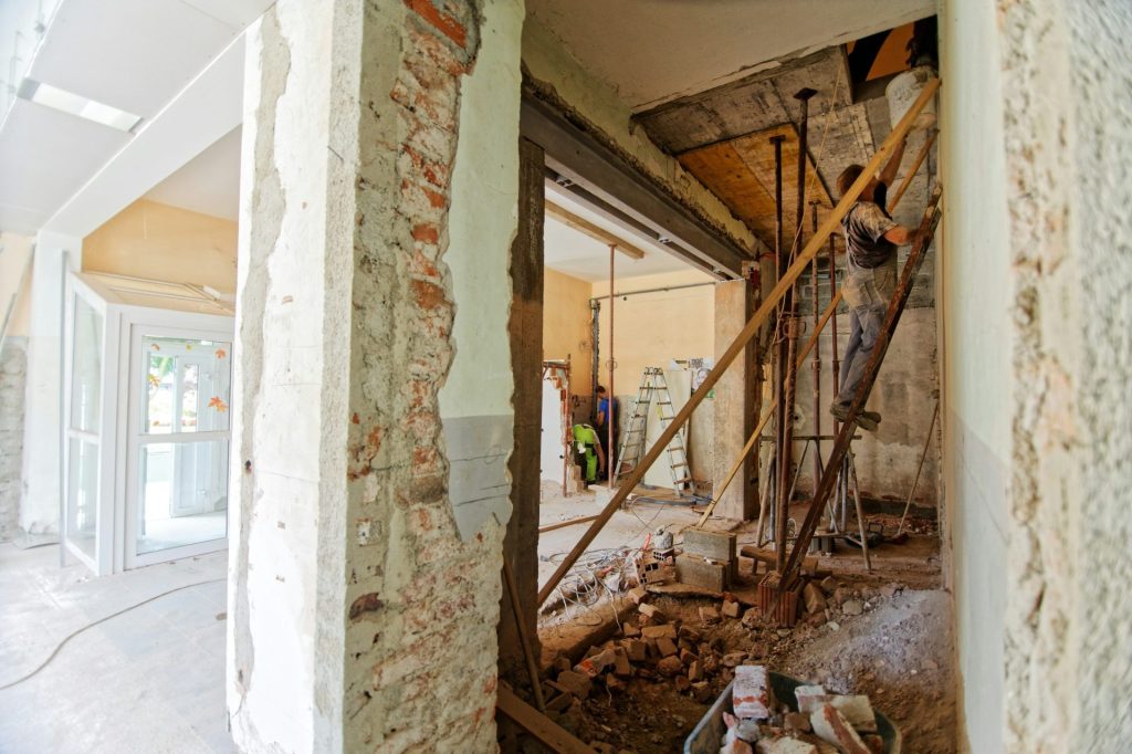 Mann klettert in einem Zimmer auf eine Leiter
